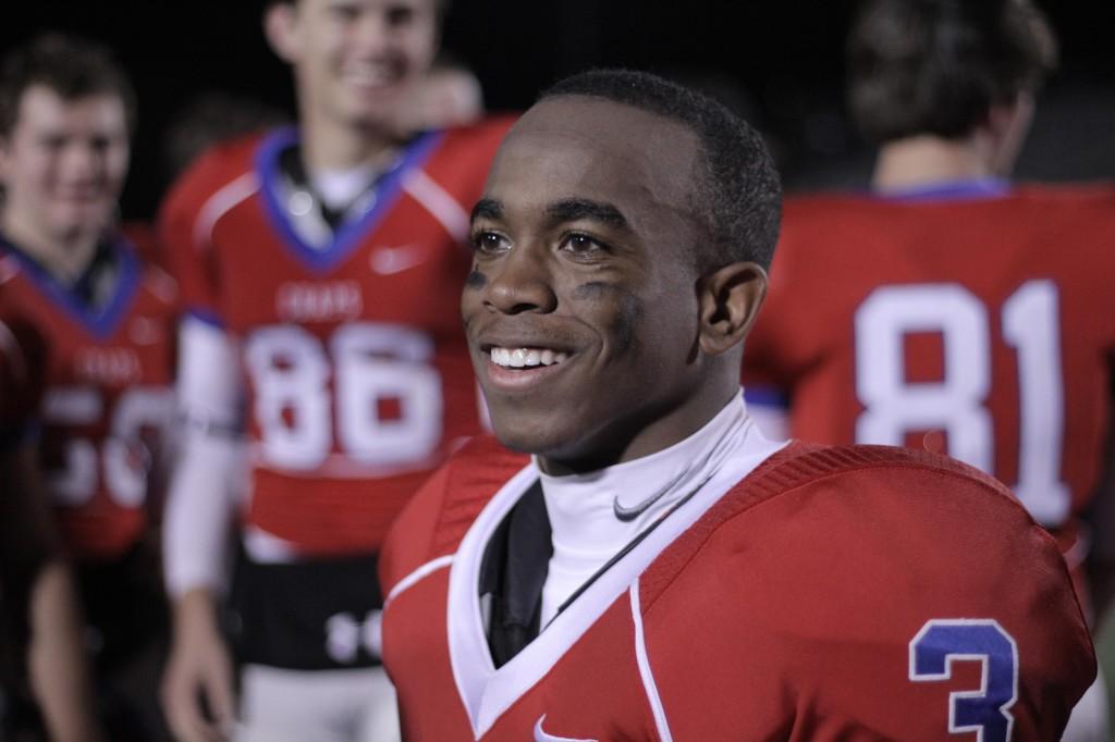 Junior Malek Jacobs swaps stories with team-mates after crushing Austin High 0- 42.