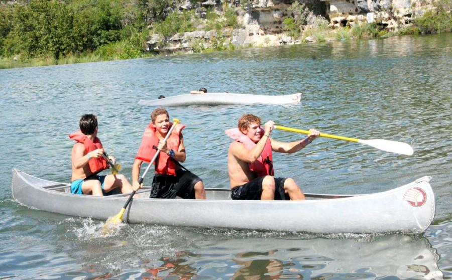 Juniors Nick Carlson and Jule Russel along with Freshman Kevin (last name) laugh as their feelow competetors canoe tips over in a rowing contest durning the anual Westlake Choirs Mo Lympics located at Mo Ranch on Sept. 6, 2014