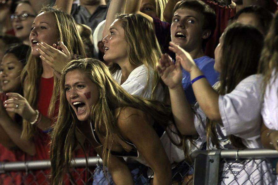 Senior Bailey Holle yells at the football game from the student section of the stands.