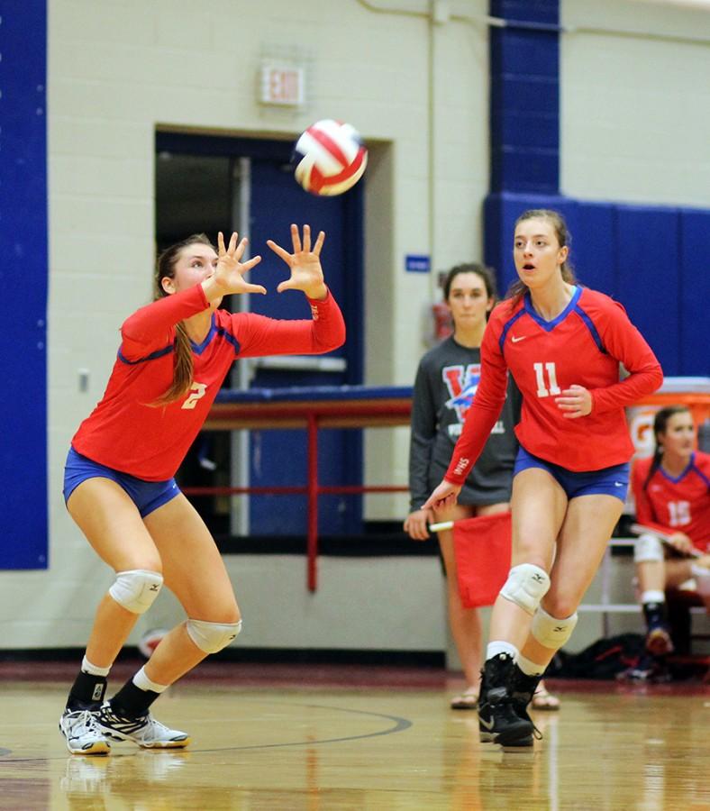 Varsity volleyball team members senior Carly Turner and junior Jessica Schwenke work together to beat their opponent during the teams game against Lake Travis on Oct. 23.