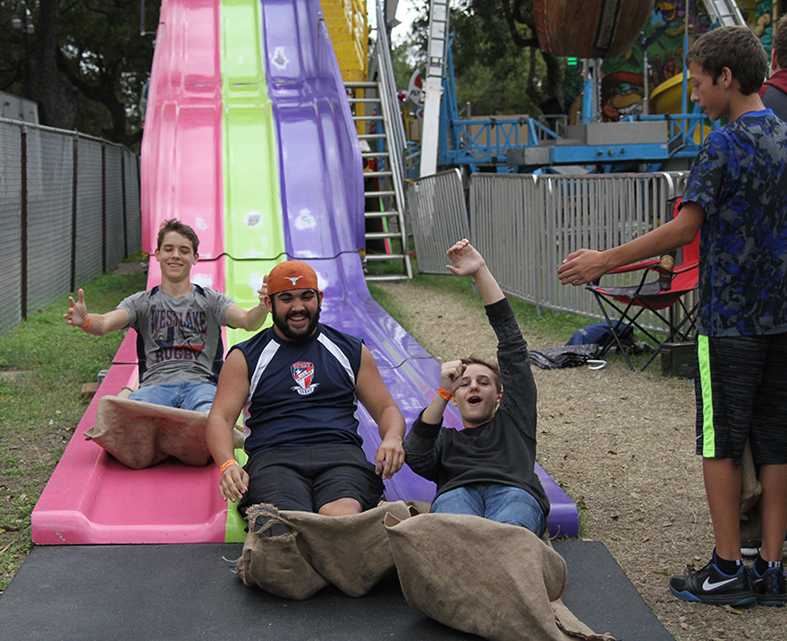 Sophomores James Perdue, Noah Shelton, and Davin Intag race down a slide at the Wurstfest in New Braunfels on Nov. 11. The Wurstfest is an annual German sausage fest where people enjoy traditional German food and music.