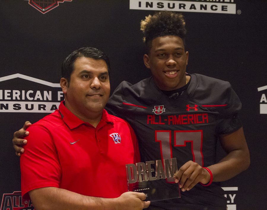 Westlake football coach Salazar posing with senior Levi Jones holding the dream in their hands.