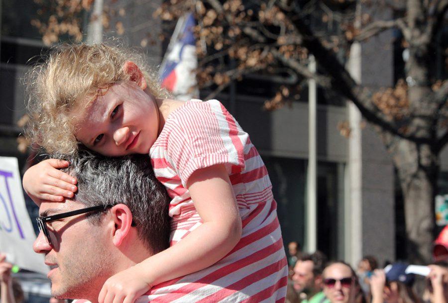 A young girl sits on her fathers shoulders while marching on Jan. 21 for womens rights.