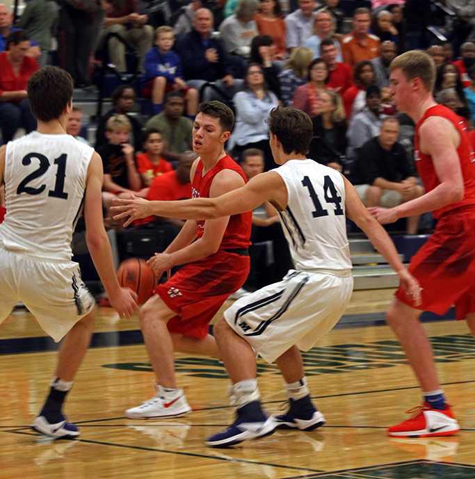 Junior Luke Pluymen being blocked during a charge down the court
