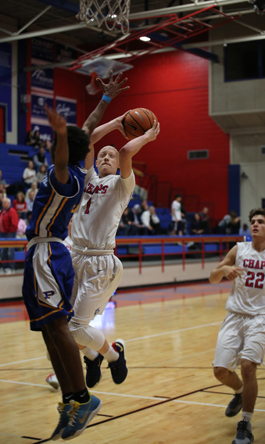 After stealing the ball, sophomore Rory Munro shoots over a Pflugerville player during the game on Dec. 5.