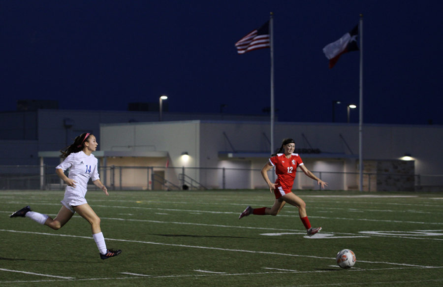 Junior Ally Huang chases after the ball in front of a defender in Westlakes April 6 playoff game vs Lake Travis.