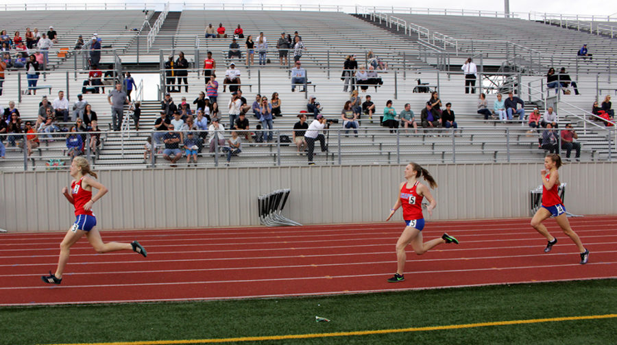 Freshman Elina Mettala, senior Lily Howe, and sophomore Elise Smoot sprint in the last 100 meters of the varsity 800 race at the District meet.
