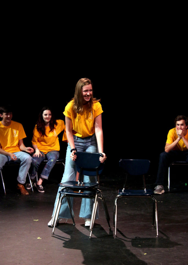 Junior Elizabeth Jackson laughs during her performance at the WIT show. She hints at her addiction to stacking chairs, which was suggested by the audience, during a game of Party Quirks.