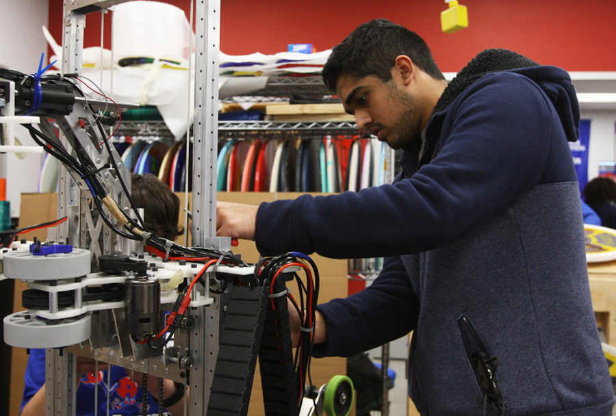 Junior Shaz Momin tinkers with a robot made by his Robotics class on Feb. 21.