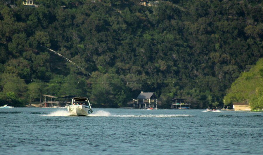 A boat glides along the water of Lake Austin April 10. Although typically crowded on weekends, COVID-19 has made the lake a special place for Austinites to escape to.