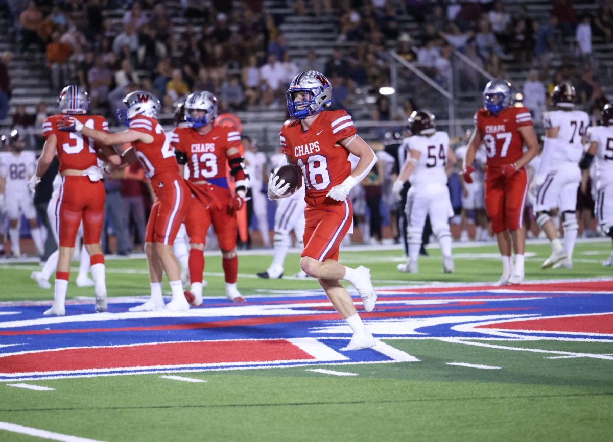Defensive+back+senior+Wyatt+Williams+carries+the+ball+as+Chaps+defense+celebrates+a+stop+in+their+27-14+win+over+Dripping+Springs