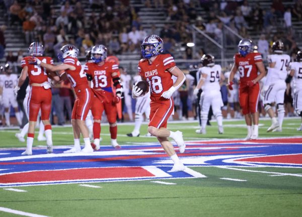 Defensive back senior Wyatt Williams carries the ball as Chaps defense celebrates a stop in their 27-14 win over Dripping Springs