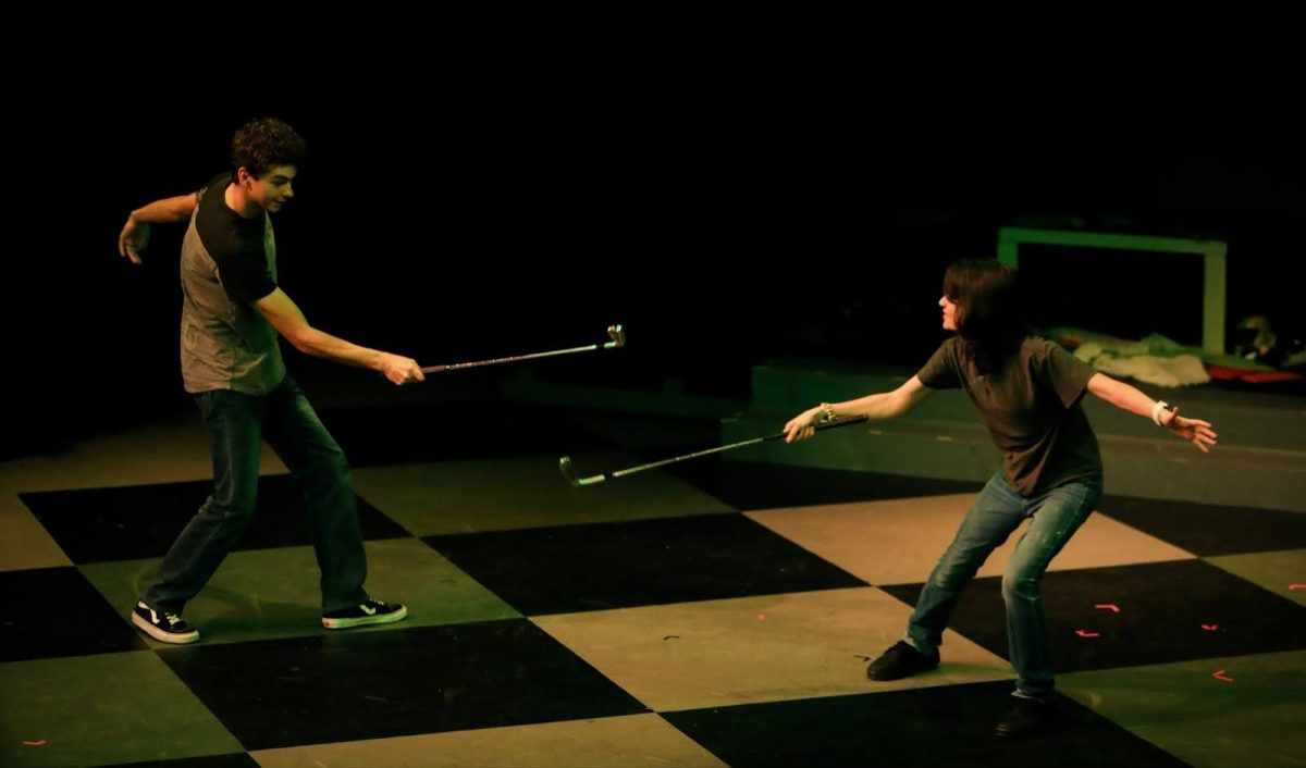 Under the dim lights of the Black Box theater Jan. 26, Senior Trent Rocha and Sophomore Nate Digiacomo sword fight with golf clubs during “Big Ben.” The intense battle is one of many duels in the show, complete with thunderstorm sound effects.