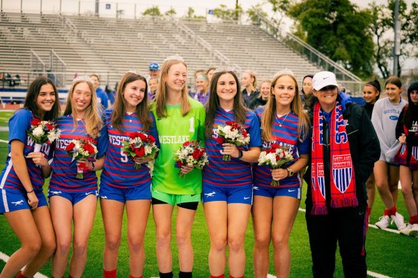 The varsity team’s six seniors pose for a photo to remember their senior night. Senior celebrations started early before the game where they received tiaras and bouquets of flowers. 