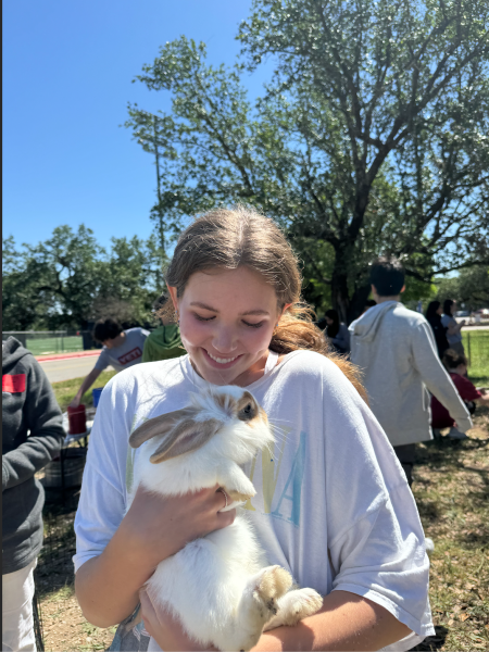 Senior Claire Dopkins poses with a fluffy bunny at the annual petting zoo. “The petting zoo is the highlight of my week every student appreciation week,” Dopkins said. “I always look forward to picking up the ducks and chickens”