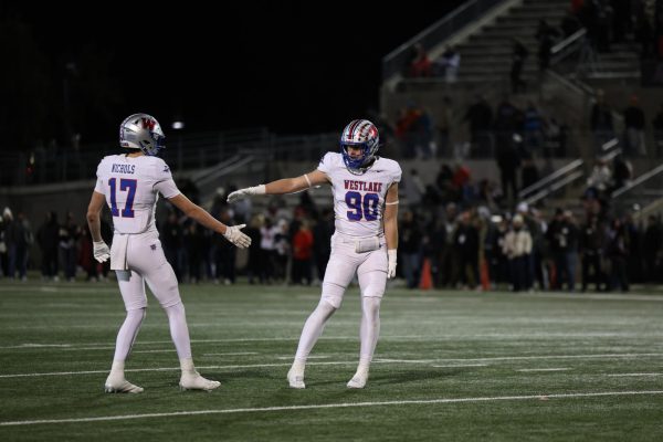 Senior defensive lineman Cullen Devine and sophomore cornerback Wylie Nichols celebrate against Lake Travis at Kelly Reeves Athletic Center Dec. 6. The Chaps took down the Cavs, moving onto the state semifinals. 