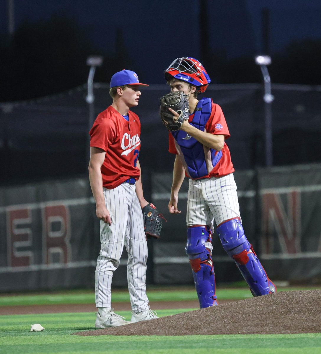 Talking at the pitcher’s mound, pitcher junior Parker Saltsman and catcher senior Hudson Byrd strategize between pitches April 8 in the Lake Travis away game.