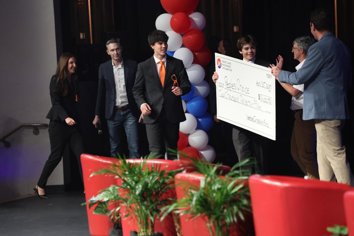 After winning the People's Choice award, juniors Worth Kieth and Don Paul Powell accept a $2,00 check from assistant principals Dianne Parks and Casey Ryan. With their check in hand, EcoGlow celebrates their earnings. Their product, EcoGlow, was an eco-friendly sunscreen.
