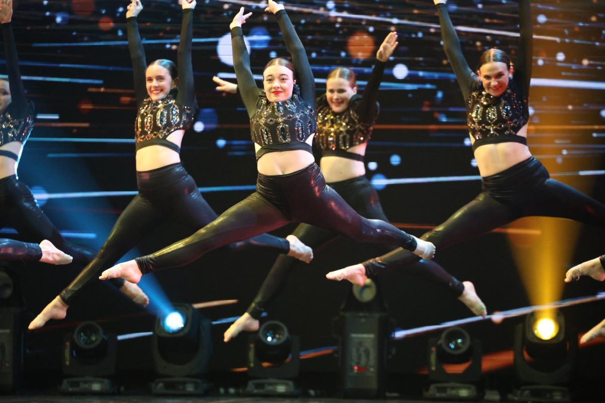 Suspended in the air, senior Bella Barany and Star Steppers jazz team members dance to "Pump it up" April 25.
