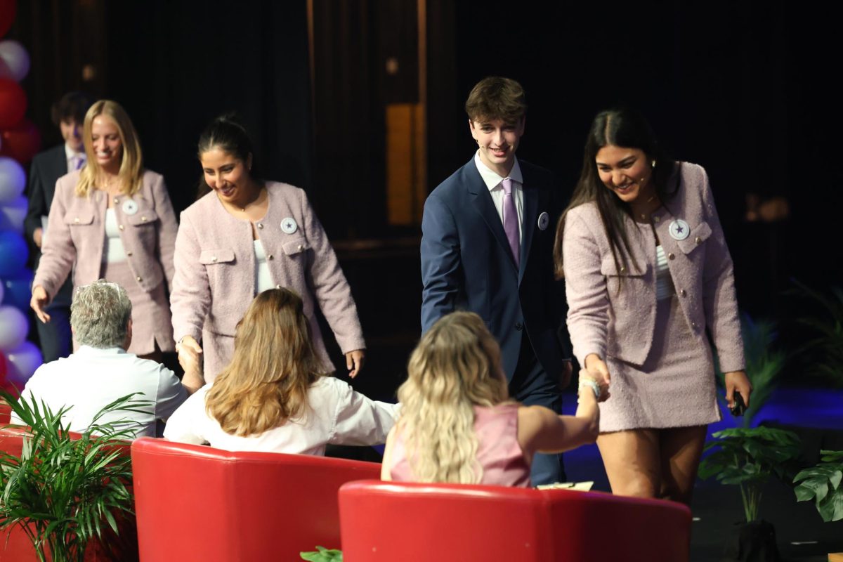 Shaking hands with the judges, the PoliticAid team gets ready to deliver their final pitch. “I was super nervous,” team member junior Anna Galatzan said. “But I was very excited and ready to present.”