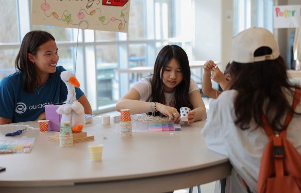 Senior Rio Thomas and senior Natalie Yung make bracelets with community members. Chinese students hosted a Chinese Culture Night April 17, 2025 where attendees could get food and fresh boba, and participate in games and crafts such as Chinese Monopoly and bracelet and lantern making.