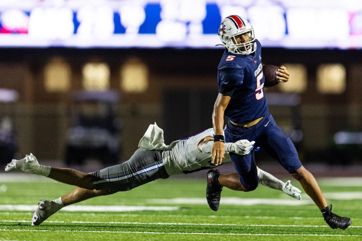 A Chaparral defender tries to wrap up Atascocita junior quarterback Isaiah Rasheed in the backfield Sept. 12 at George Turner Stadium. The Westlake defense collected six sacks en route to a 35-28 win. 