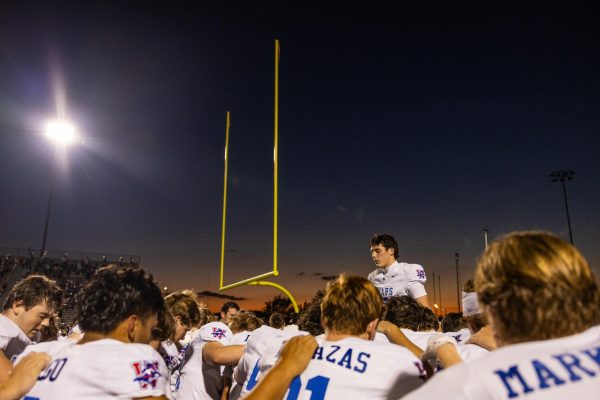 Senior quarterback Rees Wise (9) bows his head in prayer with the rest of the team prior to the Westlake Chaparral’s win over the Bowie Bulldogs Oct. 17 at Burger Stadium.