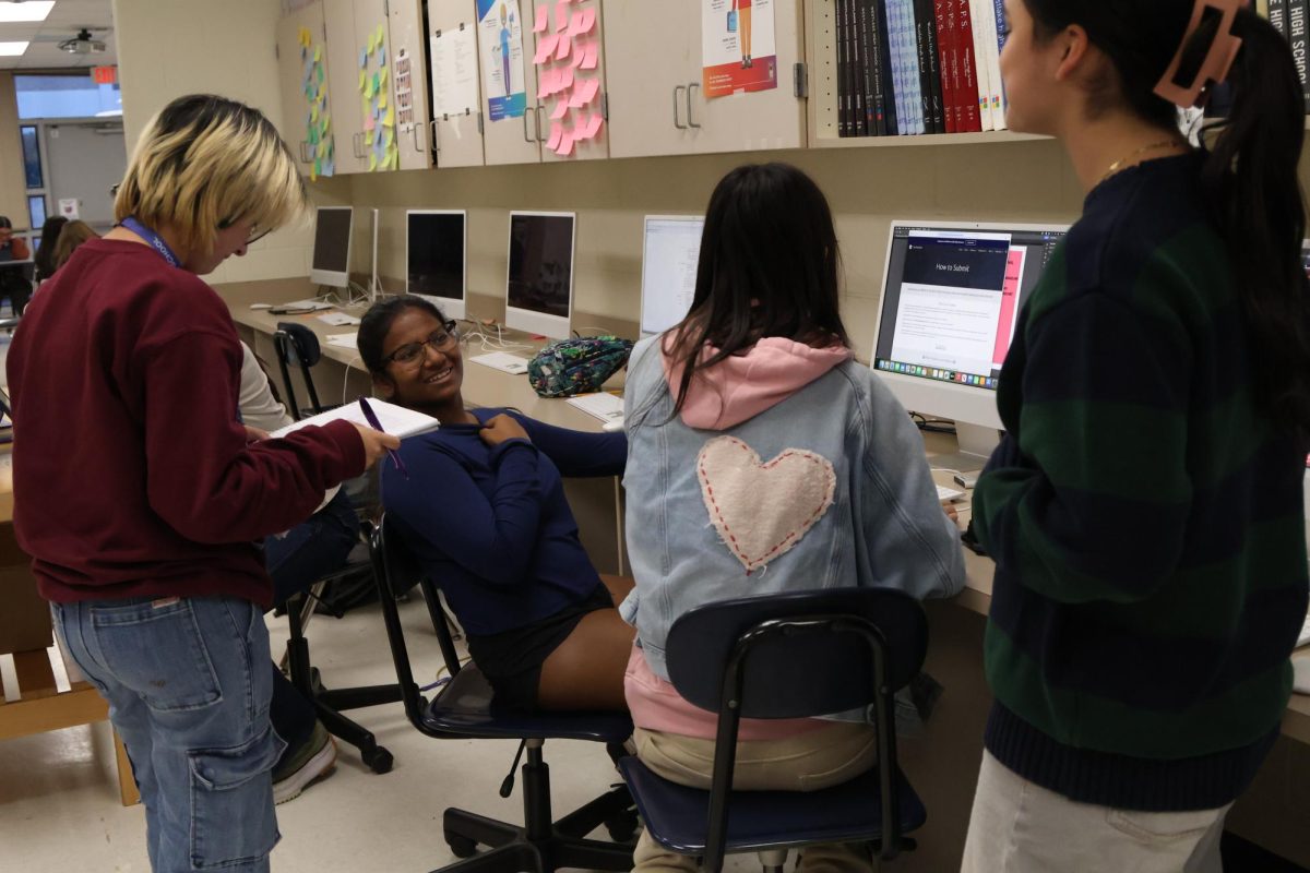 The Final Draft team brainstorms ideas for spread designs. They plan to complete the full magazine by April. 