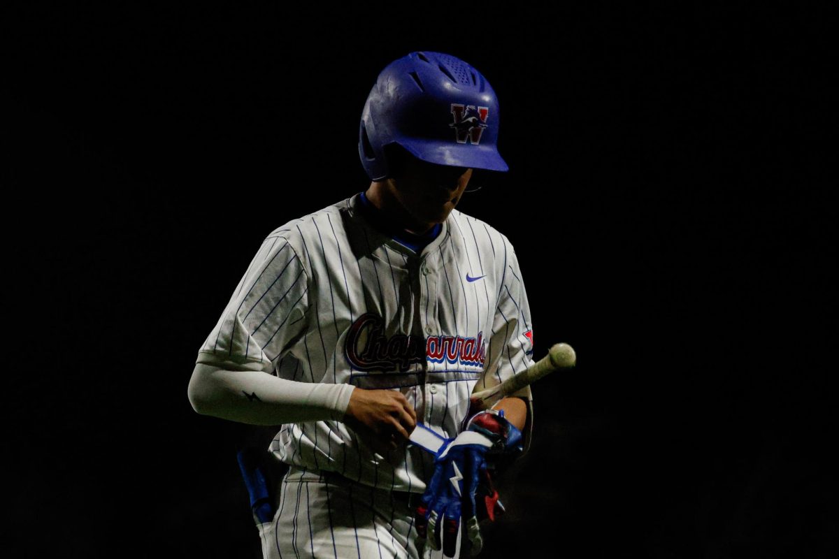 Senior shortstop Austin Knox takes off his batting gloves against Rockwall in a 4-3 win Feb. 20 at Woerner Field.