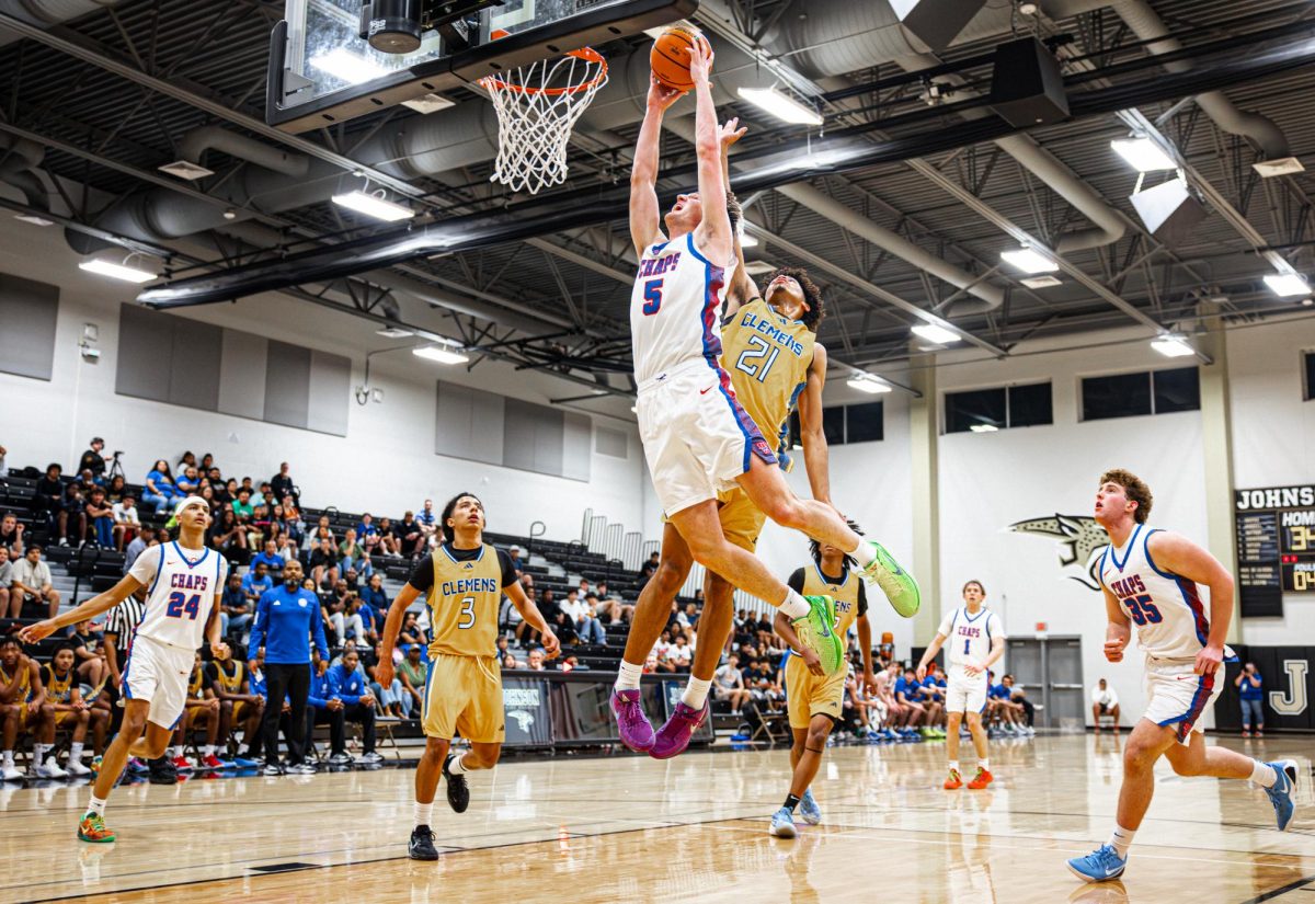 Senior guard Bo Ogden leaps for a dunk March 3 at Buda Johnson High School. Ogden led the way for the Chaps with 25 points, 17 of them coming in the first half. 
