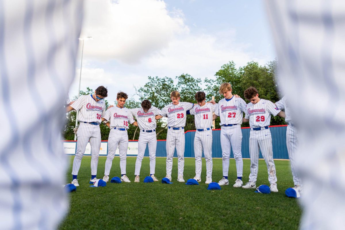 The Chaps pray in center field before the Chaps 10-4 win over the Dripping Springs Tigers April 22 at Woerner Field.